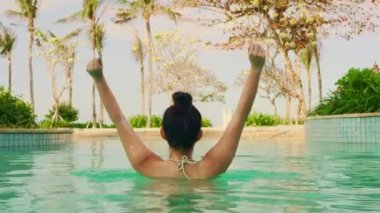 bikini ve topuz genç mutlu ve güzel Asyalı Koreli kadın lüks otel tesisi yüzme havuzu neşeli ve kaygısız yaz tatili kaçamak zevk doğal yaşam tarzı