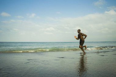 sağlıklı yaşam tarzı konsepti denizde Yaz fitness koşu egzersiz yapıyor plajda çalışan genç çekici ve uygun siyah afro Amerikan adam atletik tam vücut portresi 
