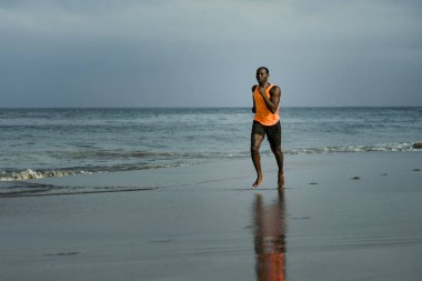 genç çekici atletik ve uygun siyah Afrikalı-Amerikalı adam sağlıklı yaşam tarzı denizde Yaz fitness koşu egzersiz yapıyor çalışan atletik tam vücut portresi