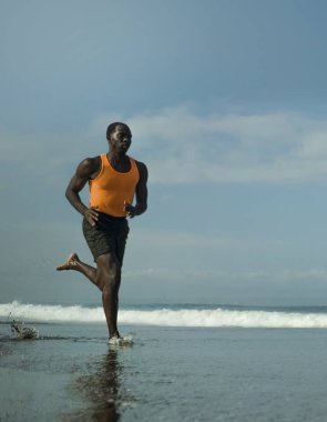genç çekici atletik ve uygun siyah Afrikalı-Amerikalı adam sağlıklı yaşam tarzı denizde Yaz fitness koşu egzersiz yapıyor çalışan atletik tam vücut portresi