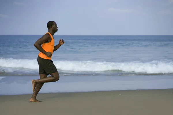 Atletisk hela kroppen porträtt av unga attraktiva och passar svart Afro American man kör på stranden gör sommaren fitness jogging Workout på havet i hälsosam livsstil Concept — Stockfoto