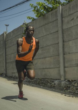 kentsel koşucu egzersiz . Genç çekici ve atletik siyah Afro-Amerikan adam asfalt yol eğitim sert spor ve sağlıklı yaşam tarzı koşu açık havada çalışan
