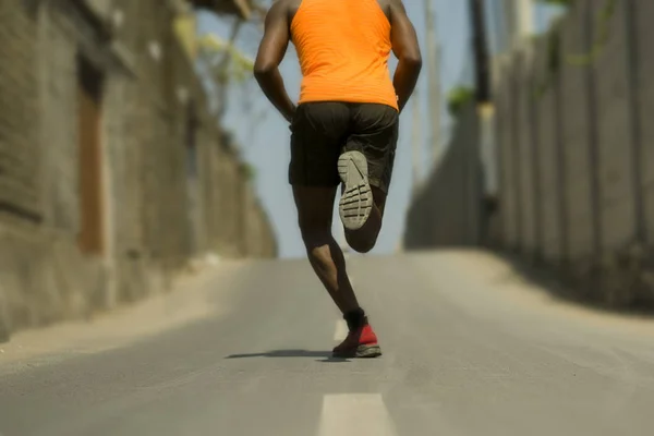 Back view of athletic black African American professional sport man running training hard outdoors on asphalt road during jogging workout in healthy lifestyle — Stock Photo, Image