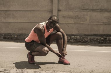 genç atletik ve şehir koşu egzersiz sırasında yaralanmalı tendon veya bağ ile tıbbi sorun yaşadıktan sonra ayak bileği tutarak ağrı zinde siyah afro Amerikan koşucu
