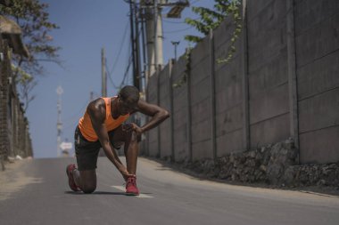 genç atletik ve şehir koşu egzersiz sırasında yaralanmalı tendon veya bağ ile tıbbi sorun yaşadıktan sonra ayak bileği tutarak ağrı zinde siyah Afrikalı Amerikalı koşucu