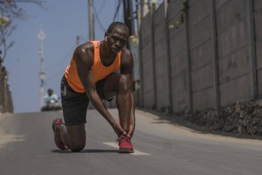 genç atletik ve şehir koşu egzersiz sırasında yaralanmalı tendon veya bağ ile tıbbi sorun yaşadıktan sonra ayak bileği tutarak ağrı zinde siyah afro Amerikan koşucu