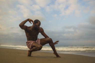 çağdaş dans koreograf ve dansçı bale plaj egzersiz yapıyor. dramatik performans dans genç bir çekici ve atletik siyah Afrikalı-Amerikalı adam 