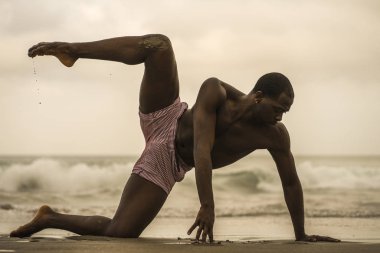 çağdaş dans koreograf ve dansçı bale plaj egzersiz yapıyor. dramatik performans dans genç bir çekici ve atletik siyah Afrikalı-Amerikalı adam 