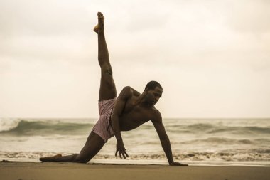 çağdaş dans koreograf ve dansçı bale plaj egzersiz yapıyor. dramatik performans dans genç bir çekici ve atletik siyah Afrikalı-Amerikalı adam 