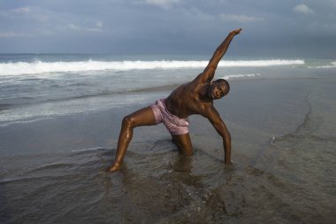 çağdaş dans koreograf ve dansçı bale plaj egzersiz yapıyor. dramatik performans dans genç bir çekici ve atletik siyah Afrikalı-Amerikalı adam 