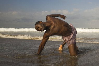 çağdaş dans koreograf ve dansçı bale plaj egzersiz yapıyor. dramatik performans dans genç bir çekici ve atletik siyah Afrikalı-Amerikalı adam 