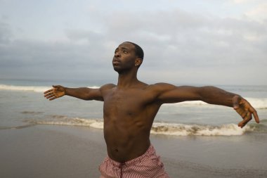 çağdaş dans koreograf ve dansçı bale plaj egzersiz yapıyor. dramatik performans dans genç bir çekici ve atletik siyah Afrikalı-Amerikalı adam 