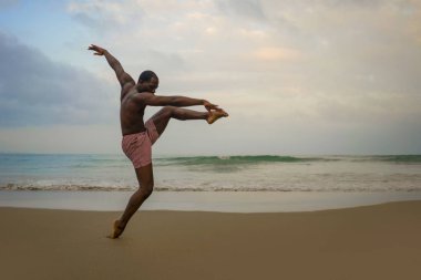 dramatik çağdaş dans koreograf bale plaj egzersiz yapıyor, genç çekici ve atletik afro siyah Amerikan adam gün doğumunda dans 