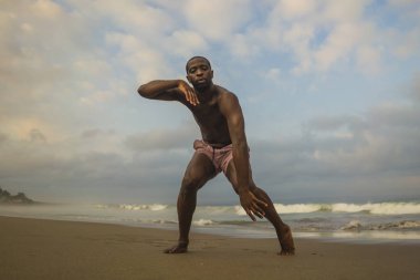 dramatik çağdaş dans koreograf bale plaj egzersiz yapıyor, genç çekici ve atletik afro siyah Amerikan adam gün doğumunda dans 