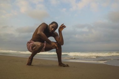 dramatik çağdaş dans koreograf bale plaj egzersiz yapıyor, genç çekici ve atletik afro siyah Amerikan adam gün doğumunda dans 
