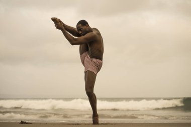 dramatik çağdaş dans koreograf bale plaj egzersiz yapıyor, genç çekici ve atletik afro siyah Amerikan adam gün doğumunda dans 