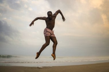 dramatik çağdaş dans koreograf bale plaj egzersiz yapıyor . genç çekici ve atletik afro siyah Amerikan adam gündoğumu atlama dans