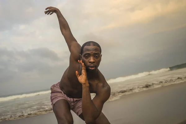 contemporary dance choreographer and dancer doing ballet beach workout . a young attractive and athletic black African American man dancing in dramatic performance