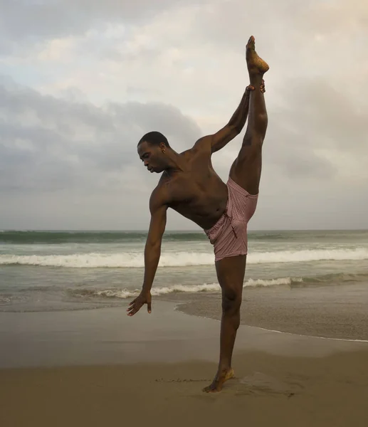 Coreógrafa de danza contemporánea y bailarina haciendo ejercicios de ballet playa. un joven atractivo y atlético negro afroamericano bailando en una actuación dramática — Foto de Stock