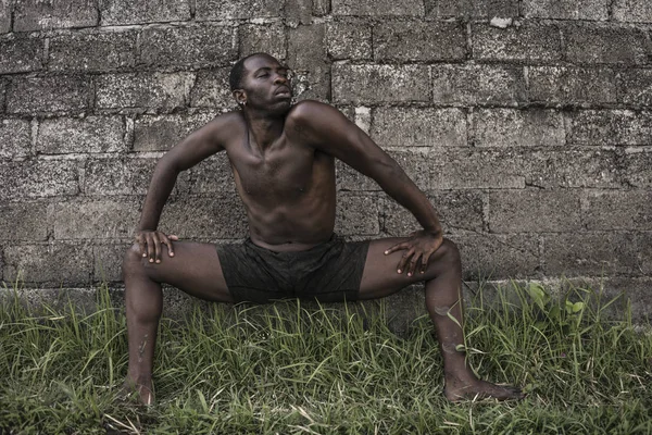 Joven y atractiva bailarina de ballet y coreógrafa contemporánea, un afroamericano negro bailando y posando sobre el fondo del campo de arroz tropical — Foto de Stock