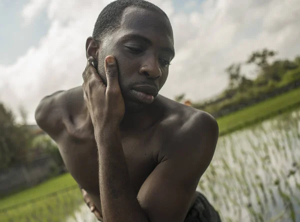 Joven y atractiva bailarina de ballet y coreógrafa contemporánea, un afroamericano negro bailando y posando sobre el fondo del campo de arroz tropical — Foto de Stock