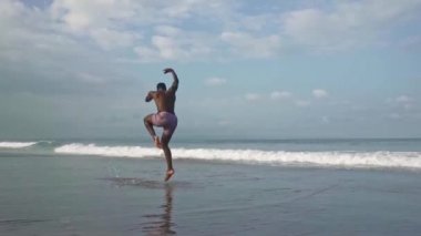 Çağdaş bale dansçısı plajda sahne yapıyor. Gerçek zamanlı ve yavaş hareket kombine gimbal genç çekici ve atletik siyah Afrikalı Amerikalı adam deniz tarafından dans vurdu