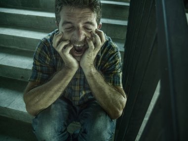 genç depresif ve üzgün adam karanlık sokak merdiveni üzerinde tek başına oturan depresyon sorunu ve anksiyete krizi umutsuz ve hasta çığlık acı