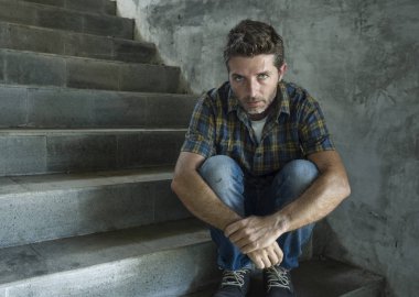 genç depresif ve üzgün adam karanlık sokak merdiveni üzerinde tek başına oturan depresyon sorunu endişeli düşünme ve sefil duygu bakıyor acı