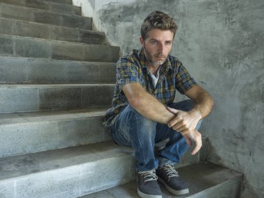 genç depresif ve üzgün adam karanlık sokak merdiveni üzerinde tek başına oturan depresyon sorunu endişeli düşünme ve sefil duygu bakıyor acı