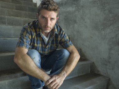 genç depresif ve üzgün adam karanlık sokak merdiveni üzerinde tek başına oturan depresyon sorunu endişeli düşünme ve sefil duygu bakıyor acı