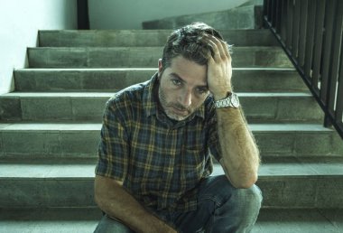 genç depresif ve üzgün adam karanlık sokak merdiveni üzerinde tek başına oturan depresyon sorunu endişeli düşünme ve sefil duygu bakıyor acı