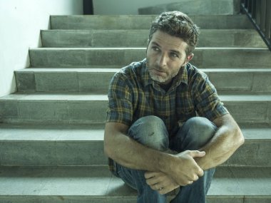 genç depresif ve üzgün adam karanlık sokak merdiveni üzerinde tek başına oturan depresyon sorunu endişeli düşünme ve sefil duygu bakıyor acı