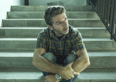 genç depresif ve üzgün adam karanlık sokak merdiveni üzerinde tek başına oturan depresyon sorunu endişeli düşünme ve sefil duygu bakıyor acı