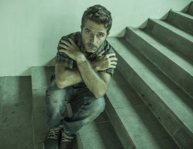 genç depresif ve üzgün adam karanlık sokak merdiveni üzerinde tek başına oturan depresyon sorunu endişeli düşünme ve sefil duygu bakıyor acı