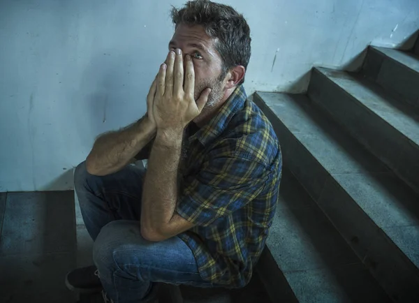 Dramático estilo de vida retrato de hombre joven deprimido y triste sentado al aire libre en la escalera de la calle oscura sufriendo depresión problema y crisis de ansiedad llorando desesperado —  Fotos de Stock