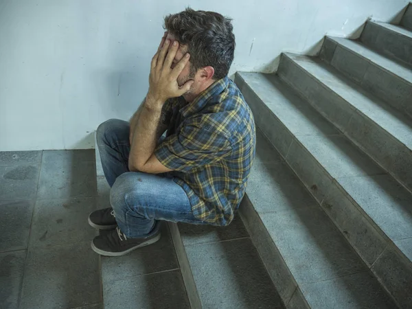 Drammatico ritratto stile di vita di un giovane uomo depresso e triste seduto all'aperto su una scala scura che soffre di depressione problema e ansia crisi disperata — Foto Stock