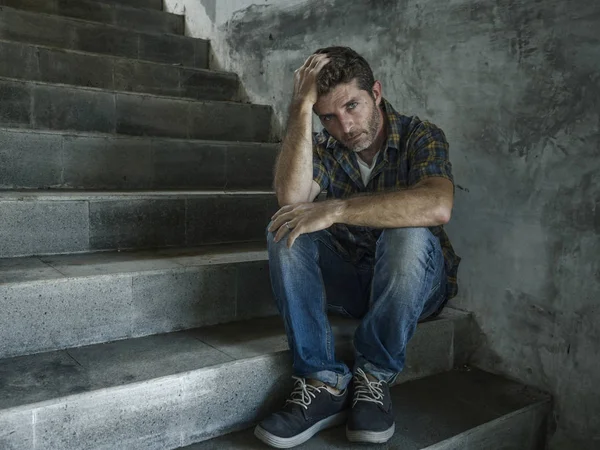 Jovem deprimido e triste homem sentado sozinho ao ar livre na escadaria de rua escura sofrendo problema de depressão olhando preocupado pensando e sentindo-se miserável — Fotografia de Stock