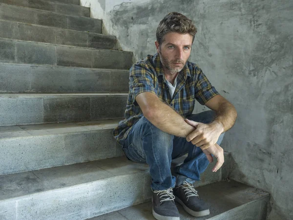 Jovem deprimido e triste homem sentado sozinho ao ar livre na escadaria de rua escura sofrendo problema de depressão olhando preocupado pensando e sentindo-se miserável — Fotografia de Stock