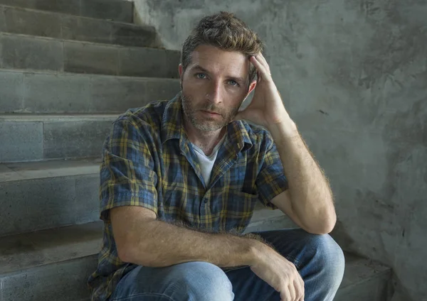 Драматический образ жизни портрет молодого депрессивного и грустного человека, сидящего на улице в одиночестве на темной лестнице, страдающего депрессией, выглядящего обеспокоенным мыслью — стоковое фото