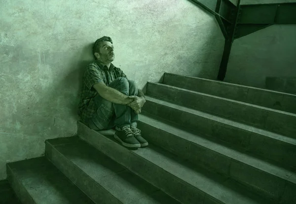 Verzweifelter Mann, der im Freien auf der Treppe einer dunklen Grunge-Straße um die Ecke sitzt und sich krank fühlt, leidet unter Depressionen und Angstkrise im Konzept für psychische Gesundheit — Stockfoto