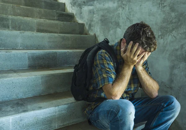 Кампания против гомофобии с молодым грустным и подавленным студентом колледжа, сидящим на лестнице, отчаянной жертвой преследования, страдающим от издевательств и жестокого обращения — стоковое фото