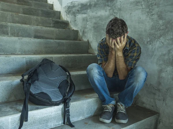 Kampagne gegen Homophobie mit einem jungen traurigen und depressiven College-Studenten, der auf einer Treppe sitzt und verzweifelt Opfer von Mobbing und Missbrauch wird — Stockfoto