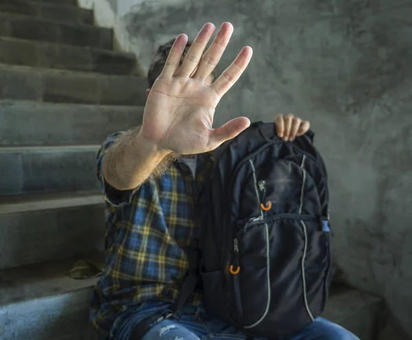 Parar o abuso de bullying e campanha de discriminação. jovem estudante homem com mochila rasing mãos cobrindo seu rosto indefeso sofrendo assédio e violência — Fotografia de Stock