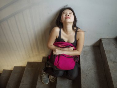 Asyalı kız üniversite öğrencisinin dramatik portresi zorbalık. Genç depresif ve üzgün Japon kız kampüs merdivenlerinde yalnız oturan zorbalık ve taciz acı