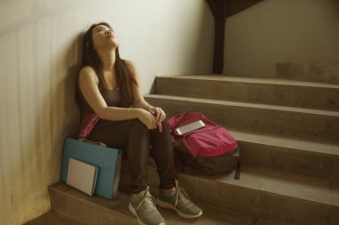 Asyalı kız üniversite öğrencisinin dramatik portresi zorbalık. Genç depresif ve üzgün Koreli kız kampüs merdivenlerinde yalnız oturan zorbalık ve taciz acı