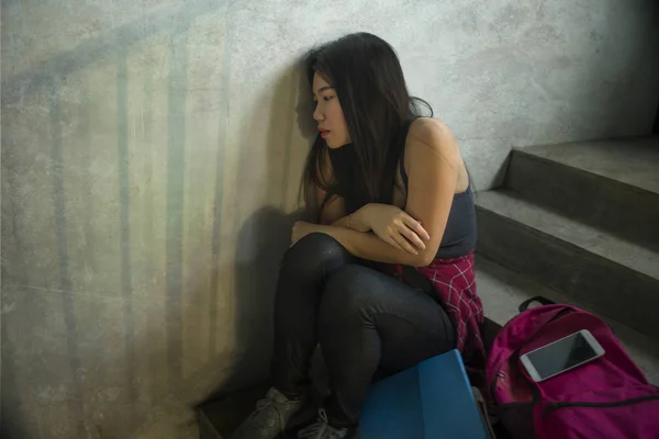 Και λυπημένη Κορεάτη που κάθεται μόνη στη σκάλα του Πανεπιστημίου και υποφέρει από εκφοβισμό και εντυπωσιακό πορτρέτο της ασιατικής γυναικείας φοιτητικής σχολής που εκφοβίζει. Νεαρή θλιμμένη και λυπημένη Κορεάτισσα που κάθεται μόνη της — Φωτογραφία Αρχείου