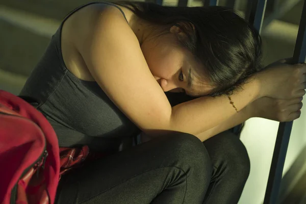 Dramatiska porträtt av asiatiska kvinnliga college student mobbade. Ung deprimerad och ledsen kinesisk flicka sitter ensam på Campus trappa lidande mobbning och trakasserier — Stockfoto