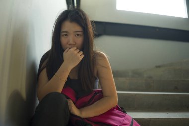 Genç güzel depresif Asya Japon üniversite öğrencisi istismar duygu merdiven kurbanı oturan korkmuş ve yalnız taciz ve zorbalık olma