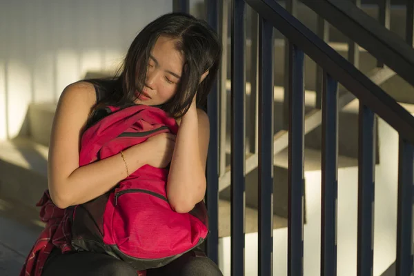 Joven hermosa deprimida asiática estudiante universitaria coreana sentada en la escalera del campus víctima de abuso sintiéndose asustada y sola siendo acosada y acosada — Foto de Stock