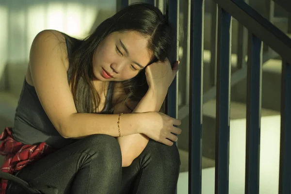 Jonge mooie depressieve Aziatische Koreaanse College student zittend op campus trap slachtoffer van misbruik gevoel bang en eenzaam wordt geïntimideerd en gepest — Stockfoto